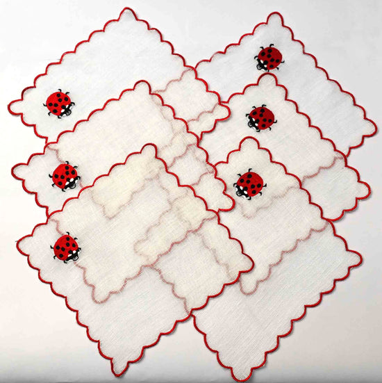 White linen cocktail napkins with  beetle embroidery.