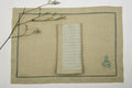 Natural coloured  embroidered linen placemats  and blue and natural striped linen napkins.