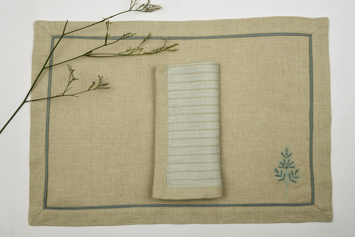 Natural coloured  embroidered linen placemats  and blue and natural striped linen napkins.