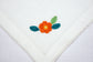 White linen with yellow and orange floral placemats and napkins.