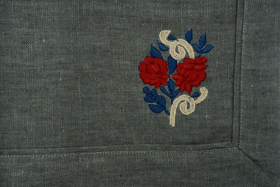 Blue linen placemats with floral embroidery and natural napkins with blue flange.
