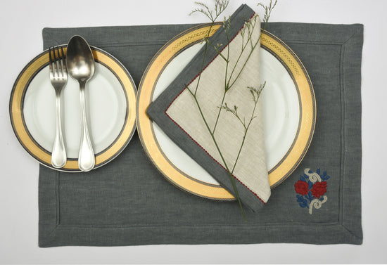 Blue linen placemats with floral embroidery and natural napkins with blue flange.