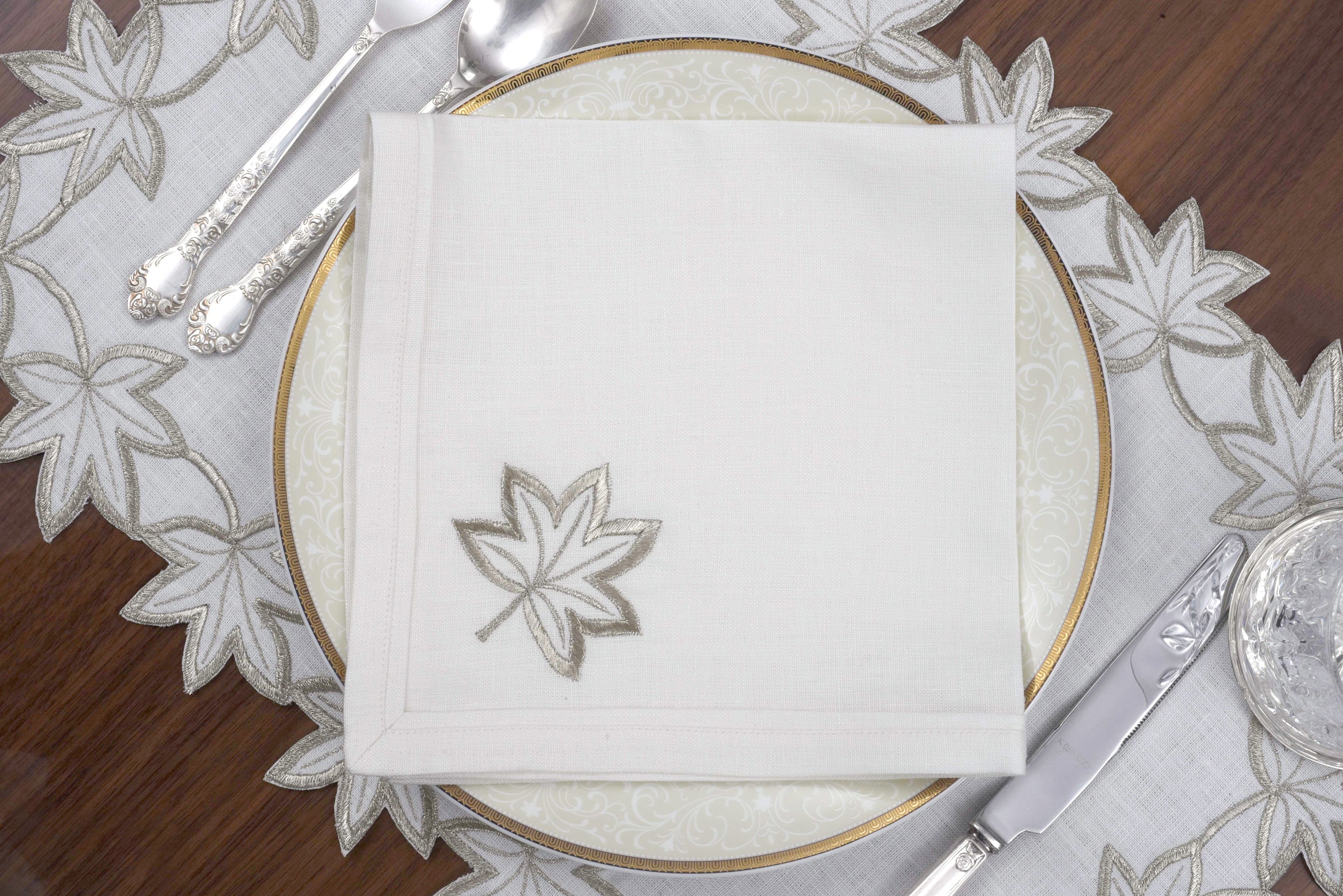 White linen placemats and napkins with gold  cutwork embroidery.