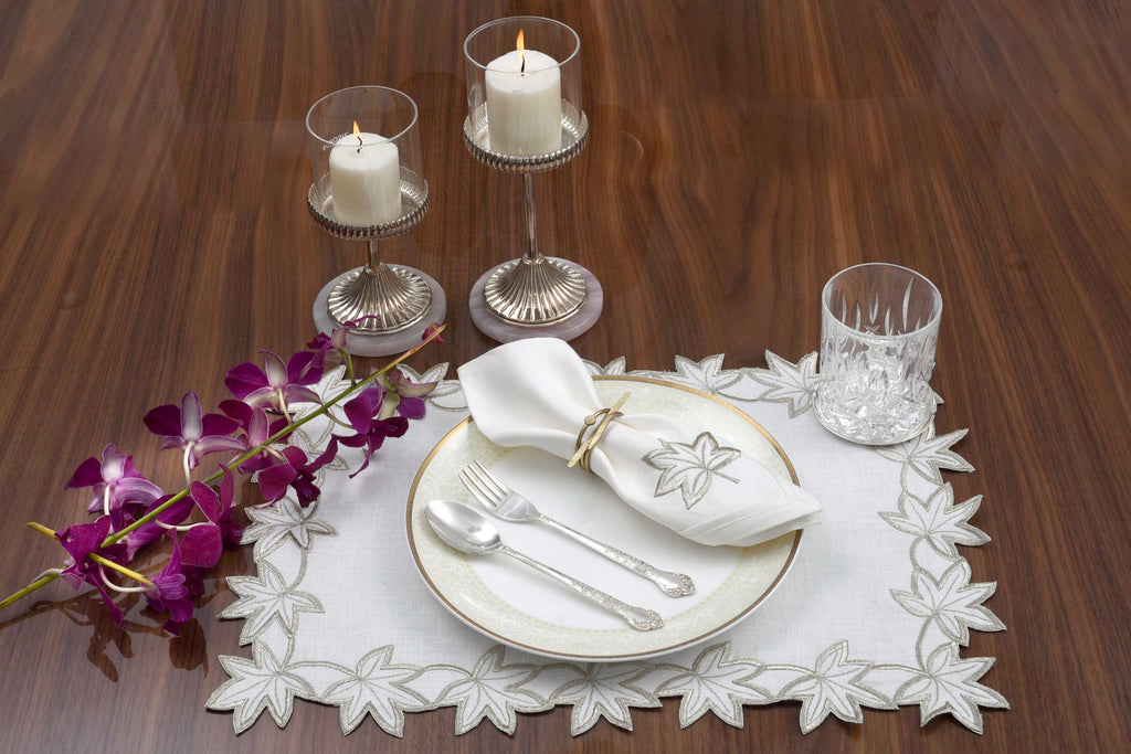 White linen placemats and napkins with gold  cutwork embroidery.