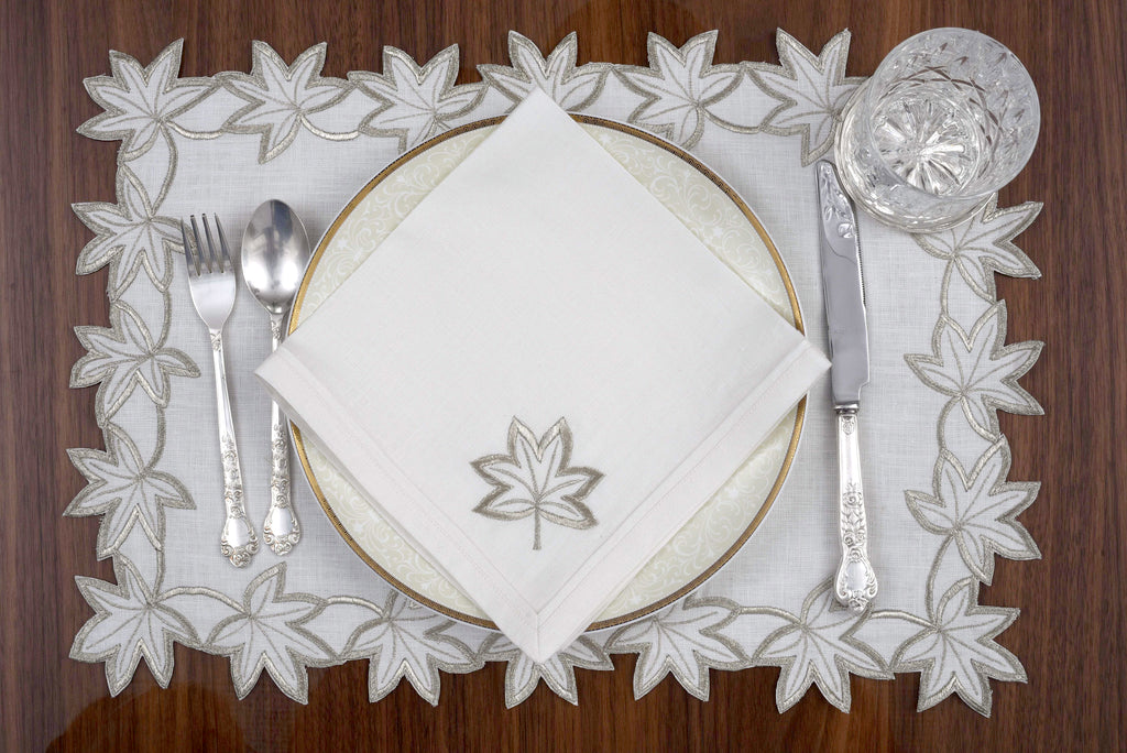 White linen placemats and napkins with gold  cutwork embroidery.