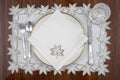 White linen placemats and napkins with gold  cutwork embroidery.