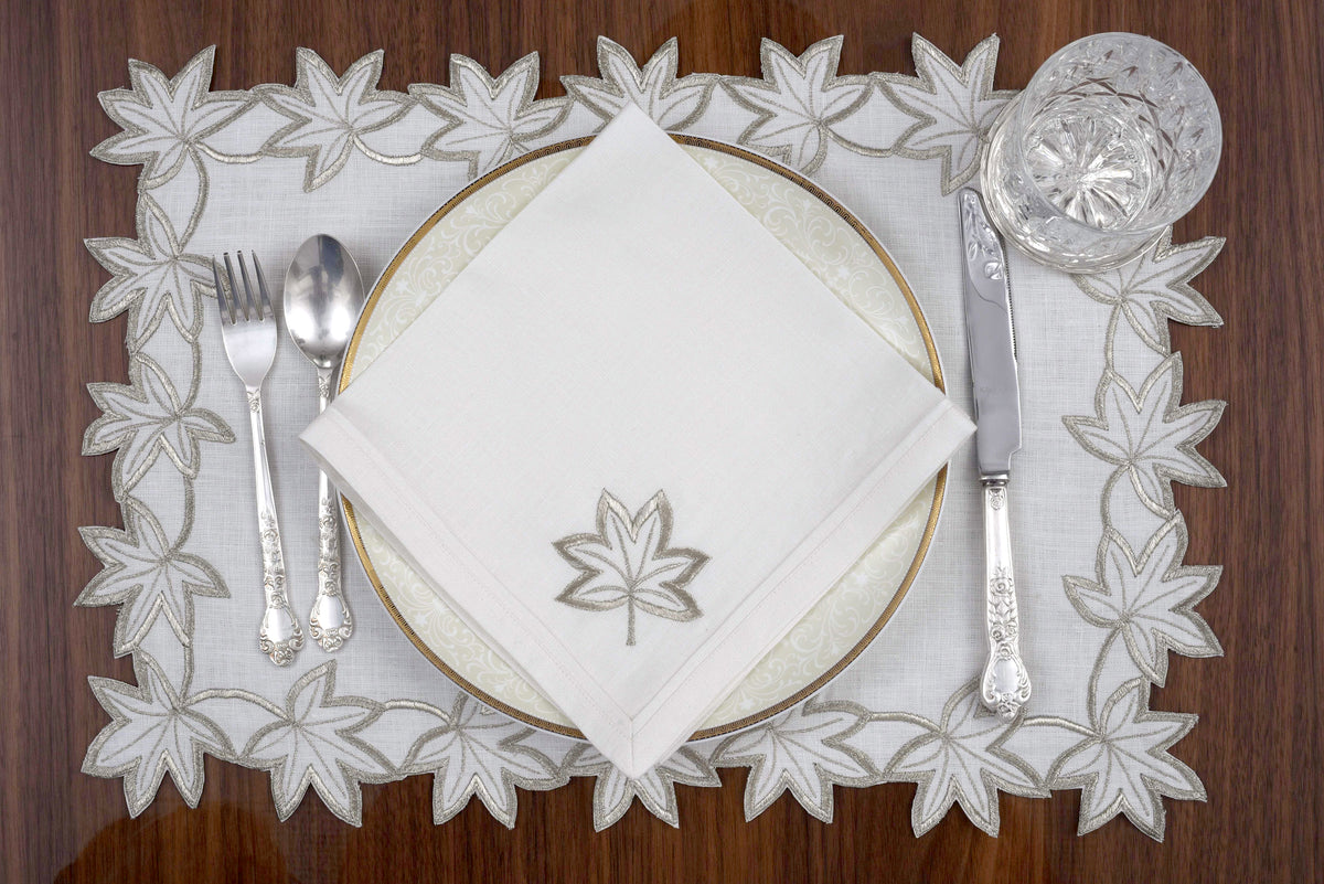 White linen placemats and napkins with gold  cutwork embroidery.