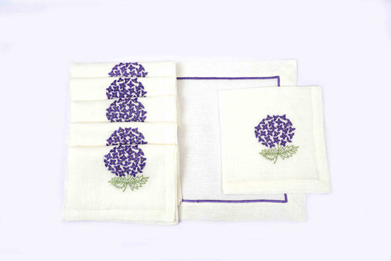 White linen placemats with purple embroidery and napkins with embroidered hydrangea.